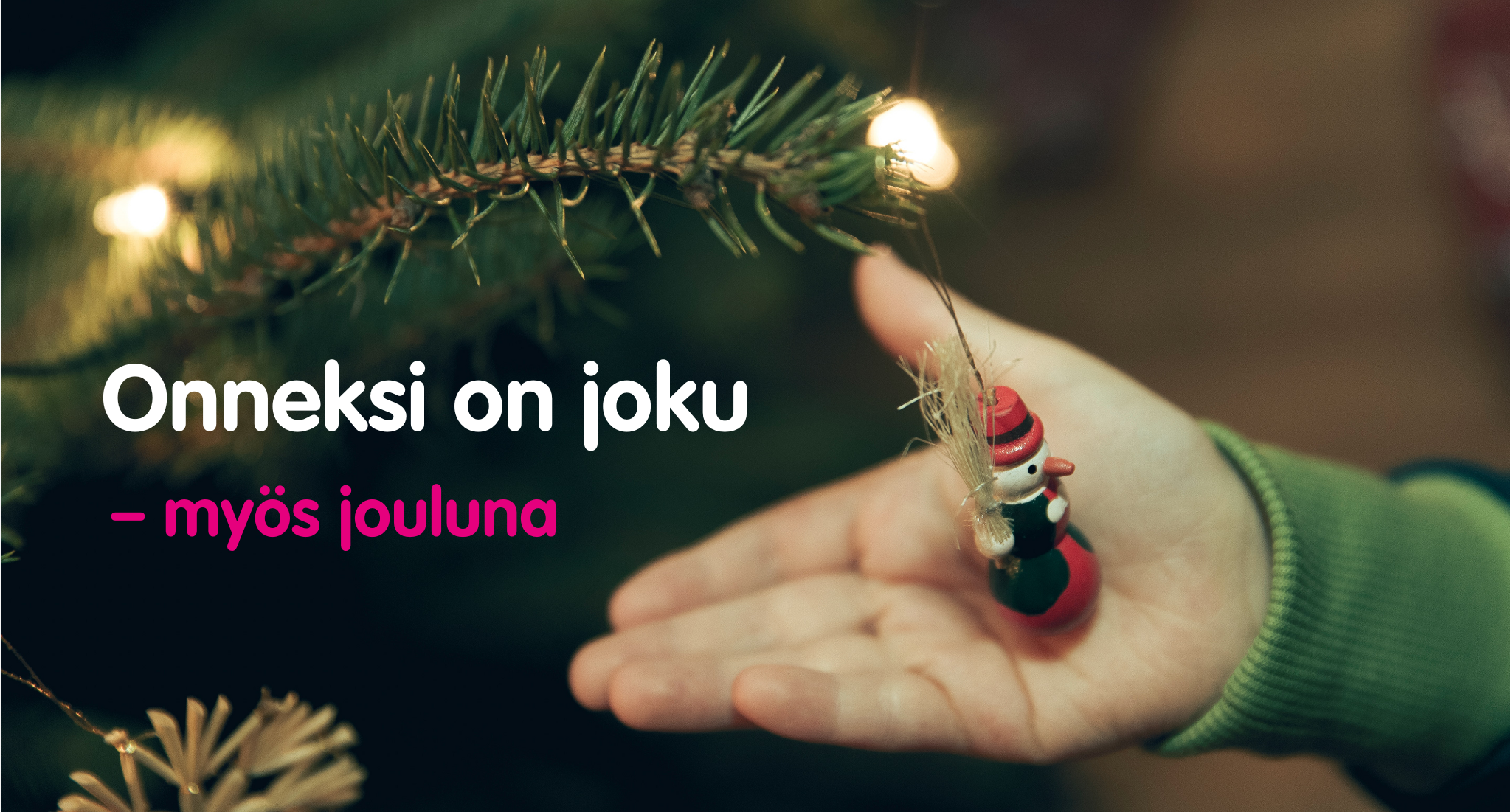 Kuusenoksassa olevaa joulukoristetta pitelevä käsi, jonka vieressä teksti Onneksi on joku - myös jouluna.